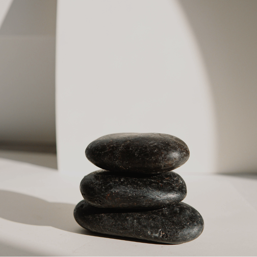 Stack of three black stones on a light background