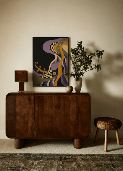 A mid-century modern dark wood credenza or sideboard cabinet styled in a warm, minimalist room. Above it hangs a colorful abstract art print featuring purple, gold, and black.