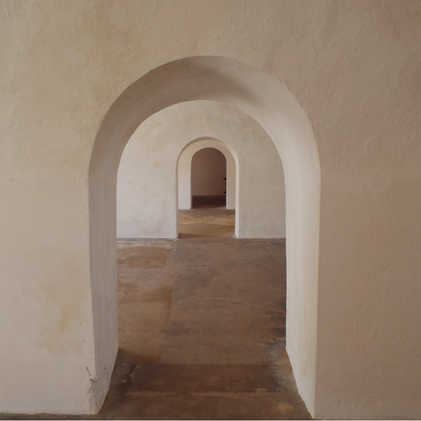 Arched passageway in a beige-walled building