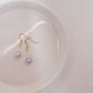 pink pearls with gold plated 18c dangle hardware laying on a ceramic plate 