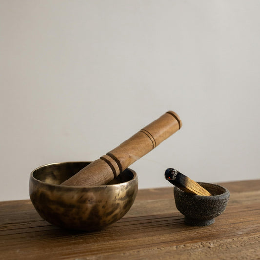 beautifully handcrafted singing bowls on rustic bench with palo santos cleanser stick 
